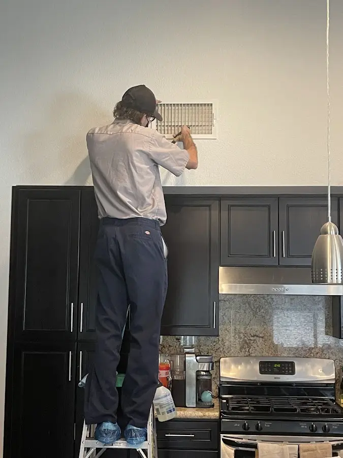 Technician inspecting an air vent during HVAC service in East Pennsboro